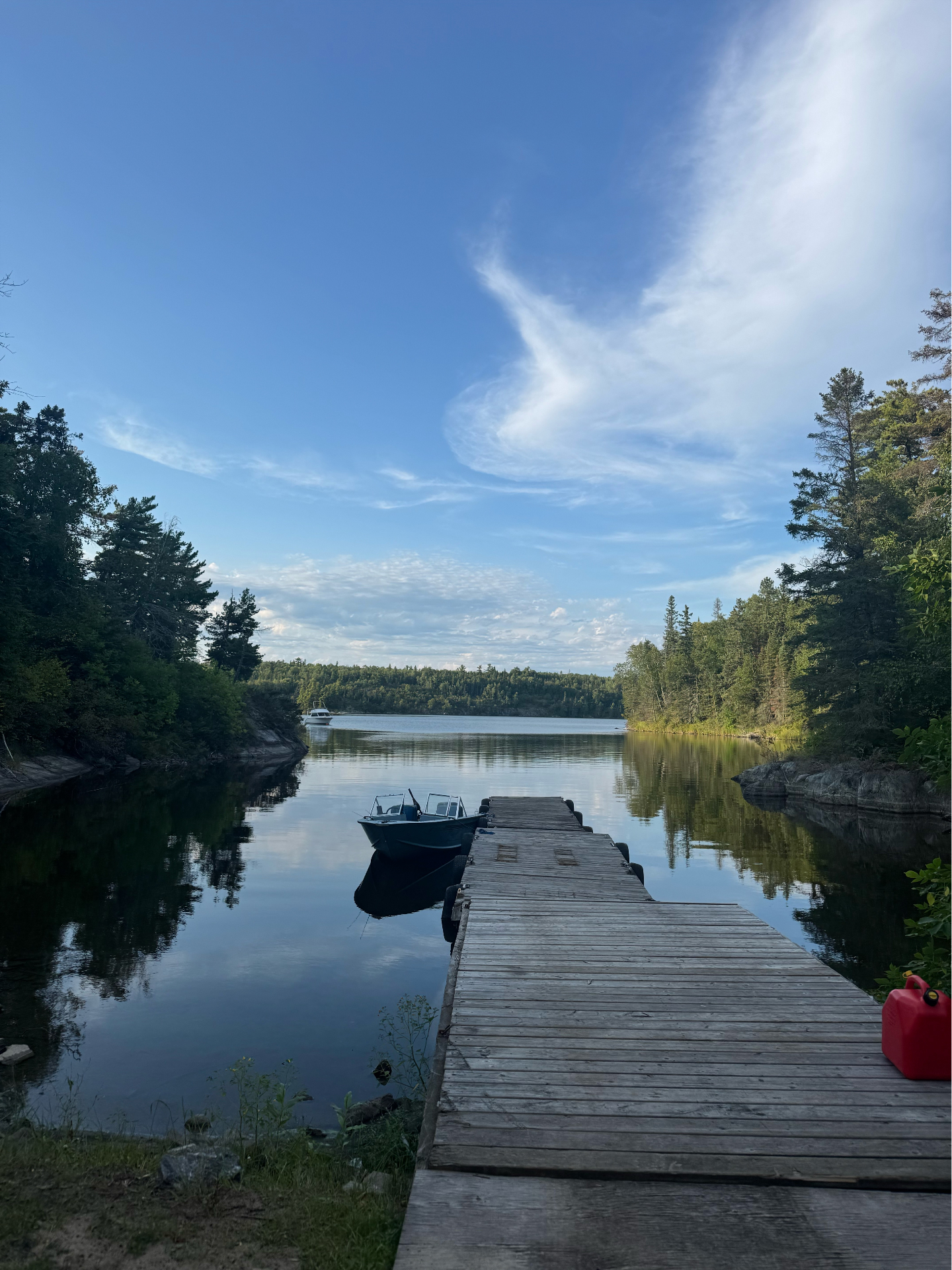Cedar dock and boat on calm water